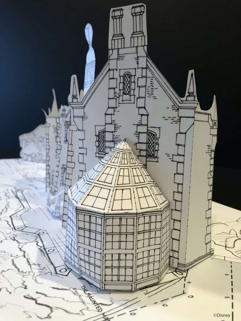 A detailed black-and-white paper replica of the Haunted Mansion, complete with intricate artistic touches and a signature glass dome, inspired by Disney Paper Parks and Imagineering magic.