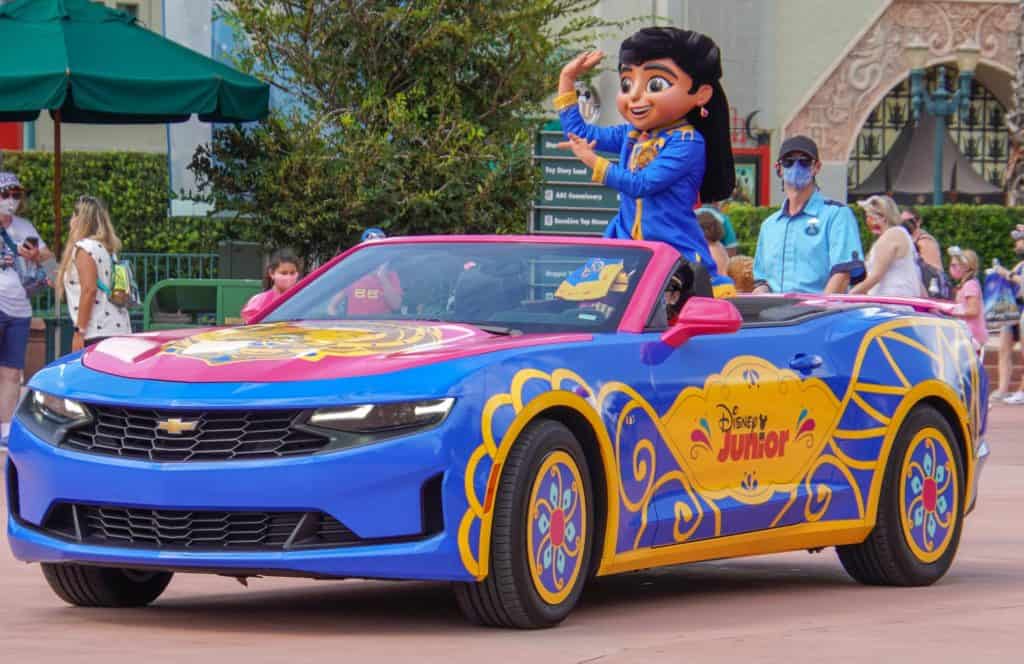Mira Royal Detective greets fans from a colorful Disney Junior-themed convertible as she waves to guests along the parade route at Hollywood Studios.
