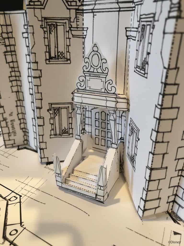 A Disney Imagineering-inspired paper model recreating a whimsical theme park entrance, complete with grand steps and magical architectural touches reminiscent of iconic Main Street facades.