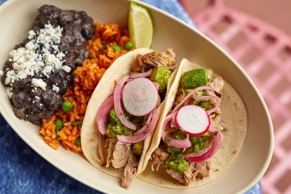 Savor two pork tacos topped with salsa, pickled onions, and fresh radishes, paired with rice, black beans, and a lime wedge—one of the delicious new dishes debuting at Disney’s Hollywood Studios as part of the latest restaurant updates.