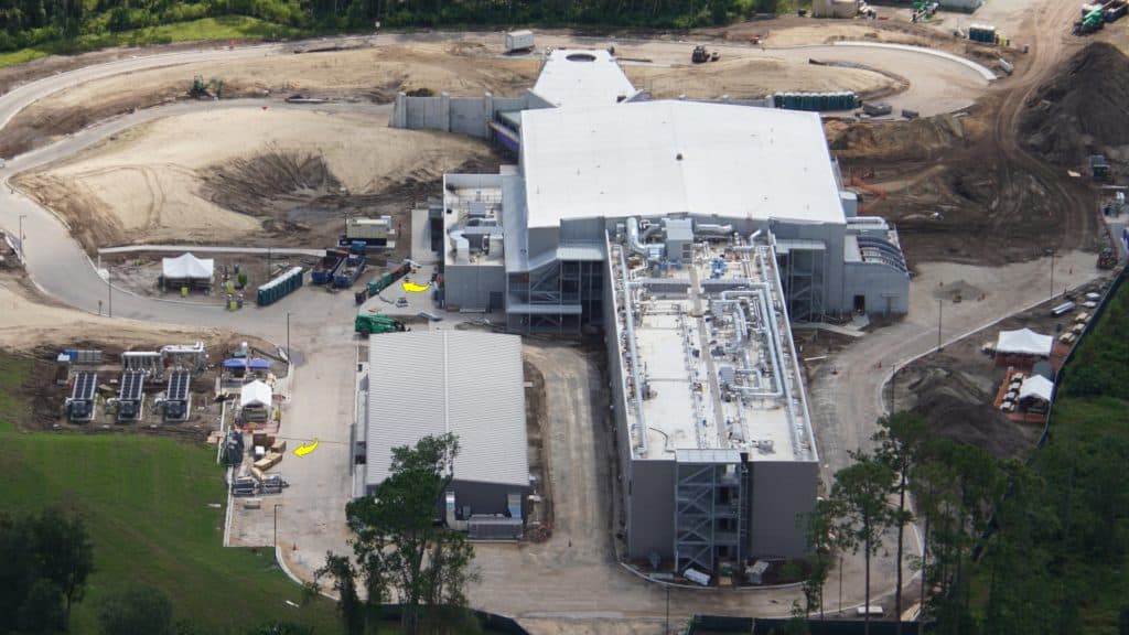 Aerial construction view of a massive gray structure taking shape at Walt Disney World, surrounded by earthworks, cranes, and temporary facilities—this future site would soon transport guests into the immersive world of Star Wars: Galactic Starcruiser.