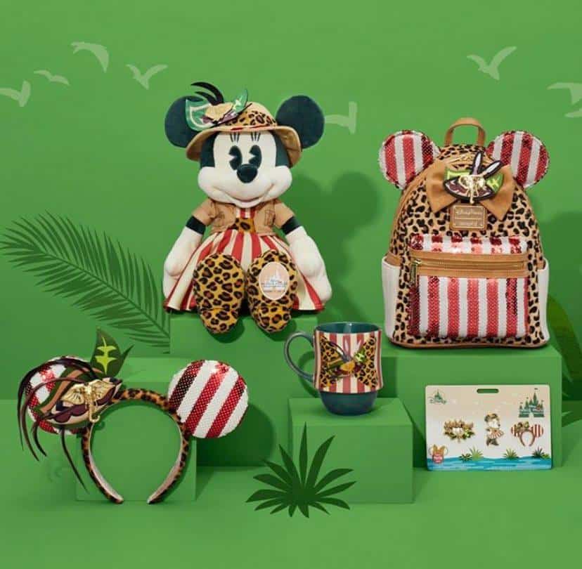 Minnie Mouse safari plush, mug, backpack, and ear headband featuring animal prints displayed on green stands—exclusive MerchPass collectibles inspired by Jungle Cruise, showcased for Disney Parks fans seeking adventure-themed memorabilia.