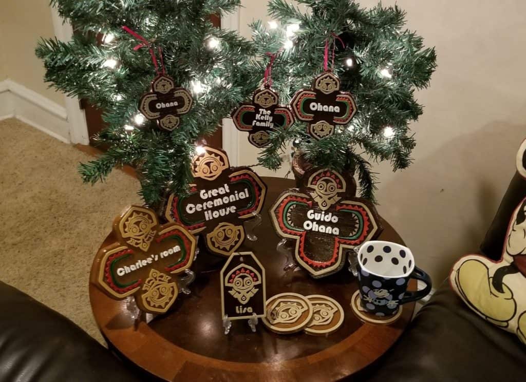 A festive round table inspired by Disney’s Polynesian Village Resort, featuring tiki-themed ornaments, two mini palm trees, a custom Polynesian Ohana Christmas sign, and a Mickey Mouse mug—perfect for adding tropical holiday magic to your Disney home decor.