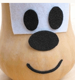 A butternut squash styled with felt to resemble a cheerful cartoon character, complete with expressive eyes, a button nose, and a big smile—a festive centerpiece that channels Disney magic, perfect for adding Pixar-inspired fun to your Thanksgiving celebration.