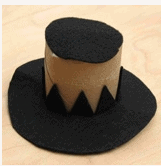 A black and brown top hat with a jagged edge design rests on a light wooden surface, ready to bring playful character to your Thanksgiving festivities in the theme park’s immersive autumn displays.