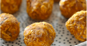 A festive close-up of Pumpkin Energy Balls and oat bites, perfectly round and ready for snacking, served on a white plate with playful black dots—ideal for fueling up before your next theme park adventure or as a magical fall treat between rides.