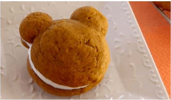 A whimsical bear-shaped cookie sandwich filled with fluffy white cream, inspired by Magical Whoopie Pies, delights guests on a charming themed plate at the park’s bakery.