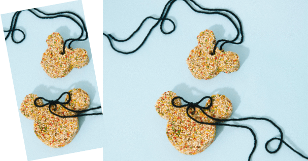 Three bear-shaped cookies decorated with colorful sprinkles and black string bows are displayed on a light blue background—just like the whimsical treats you’d find in the snack shops along Main Street at Disneyland, bringing a sprinkle of magic to your park day or serving as inspiration for adorable Disney-themed party favors.