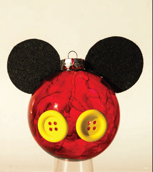 Festive red Disney ornament styled just like Mickey Mouse, featuring his iconic black ears and yellow buttons, displayed against a simple background—a charming addition for fans bringing a touch of the magic from the parks into their holiday décor.