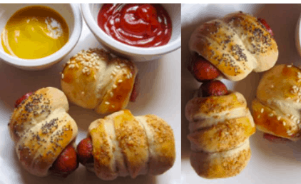 Four pigs in a blanket served with mustard and ketchup in small bowls on a white plate, perfect for fueling up before hitting the rides—these crowd-pleasing snacks are sure to be a favorite among theme park guests of all ages.