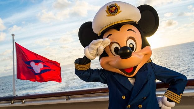 Mickey Mouse, dressed as a captain, stands on the deck of a Disney Cruise Line ship, saluting with a bright red flag nearby and the sparkling ocean behind him, capturing the excitement and adventure of setting sail with Disney.