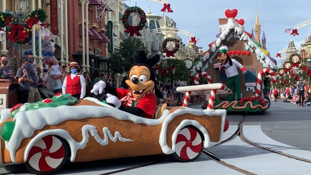Disney World’s holiday parade brings the joy of Magic Kingdom’s Christmas Cavalcades to life, with beloved Disney characters cruising in gingerbread-themed cars surrounded by dazzling festive decorations.