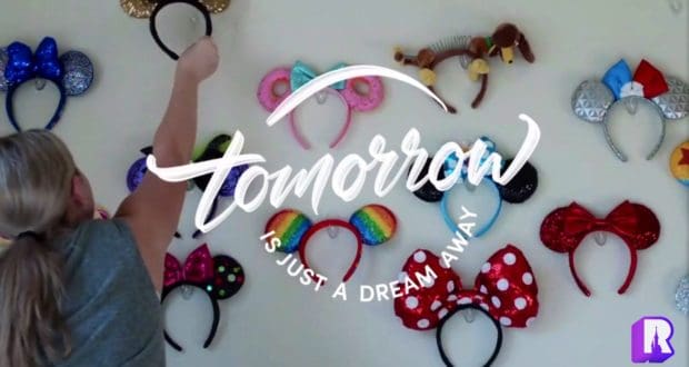 Mickey ears are being added to a vibrant display of collectible headbands on the wall, with the uplifting message "Tomorrow is just a dream away" prominently featured—highlighting Disney World’s enchanting atmosphere and nodding to the beloved anthem "Great Big Beautiful Tomorrow.
