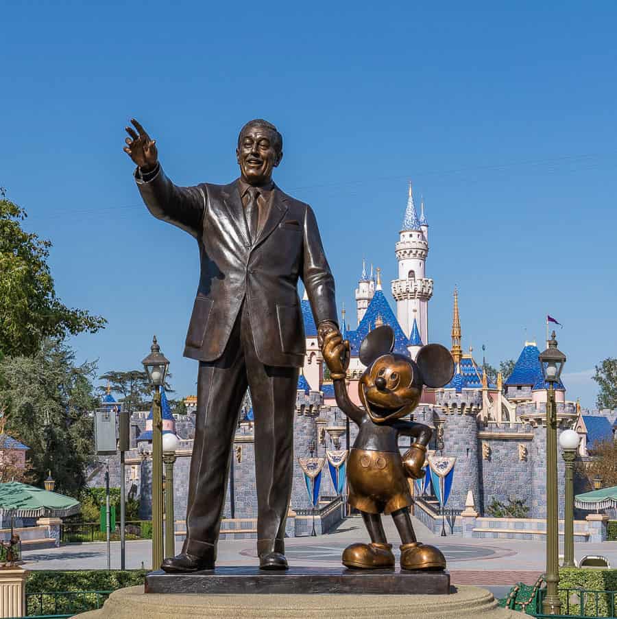 The famous Partners Statue featuring Walt Disney and Mickey Mouse hand in hand stands proudly in front of the iconic castle at Disneyland Resort, welcoming guests to the heart of Disney magic.