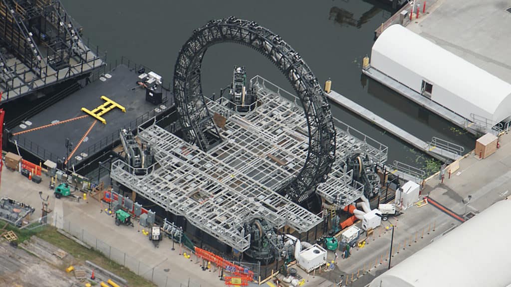 Aerial view of the massive circular stage taking shape on World Showcase Lagoon at EPCOT, surrounded by construction equipment and preparations as the park readies for the debut of HarmonioUS.