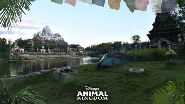 Expedition Everest’s snowy peak rises above a winding river and mysterious temple ruins in Disney’s Animal Kingdom, with vibrant prayer flags fluttering overhead and lush jungle greenery all around—captured in stunning detail with a Super Zoom Magic Shot.