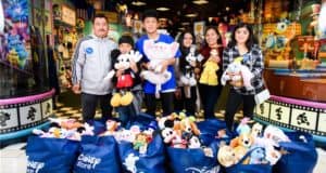 Six guests gather inside the Disney Store, each beaming with happiness as they clutch plush Disney characters, thanks to the magic of The Wish Effect. Large shopping bags overflowing with Disney stuffed animals highlight the enchanting support for Make-A-Wish, creating a moment that captures the spirit of Disney and its commitment to unforgettable wishes.