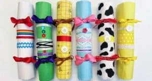 Six vibrant rolled papers, each featuring unique ribbons, buttons, and festive patterns, are lined up side by side—ideal for adding extra magic to your holiday at a theme park or creating DIY crackers for a parade celebration on Main Street.