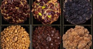 A mouthwatering grid of six legendary Gideon's Bakehouse cookies at Disney Springs, each cookie brimming with over-the-top chocolate chips, nuts, and crunchy toppings—a dream lineup for any Disney foodie or snack-loving parkgoer.