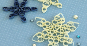 Paper quilled snowflakes inspired by Frozen Fairy Snowflakes and sparkling sequins bring a touch of Arendelle magic to a light blue polka-dotted background, making these decorations perfect for fans creating Disney Parks-inspired crafts.