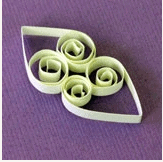 Green paper coils and teardrop shapes styled for Disney's Frozen crafts are arranged on a purple background, evoking the creativity of a themed activity you might find at Walt Disney World or Disneyland.