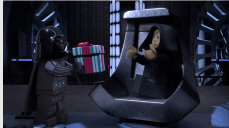 LEGO Darth Vader surprises LEGO Emperor Palpatine with a gift inside a dramatic, sci-fi throne room setting, capturing the joyful spirit and playful surprises visitors love about LEGO Star Wars Holiday Special experiences at themed entertainment destinations.