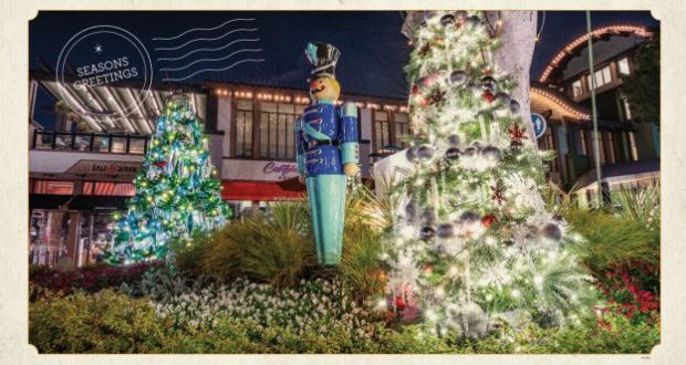 Downtown Disney sparkles with Christmas lights as towering trees twinkle beside a classic toy soldier statue and a cheerful "Season's Greetings" sign. The atmosphere buzzes with holiday spirit, surrounded by iconic Disney shops and tasty quick-service dining options perfect for fueling your festive visit.