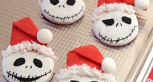 Sandy Claws Cookies, featuring Jack Skellington sporting cheerful Santa hats, await guests on a silver tray—an irresistible holiday treat found during festive celebrations at Disneyland.