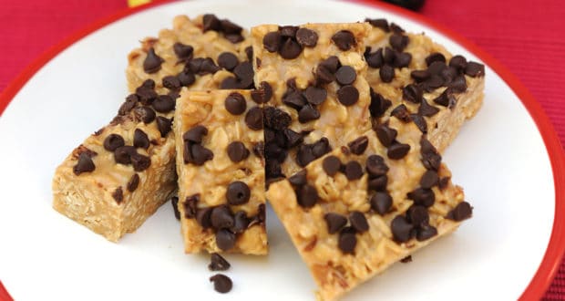 No-bake oatmeal bars topped with chocolate chips, served on a white plate with a red rim, just like the beloved granola treats from Disney’s Contemporary Resort—a favorite Disney Parks snack enjoyed by fans of magical eats.