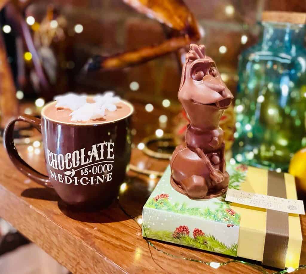 Hot chocolate topped with fluffy whipped cream and a festive chocolate reindeer sits atop a decorative box, specially crafted to celebrate The Ganachery’s 5th Anniversary at Disney Springs.