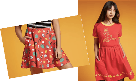 Two girls in vibrant, patterned red dresses from the latest Hot Topic collection channel energetic theme park vibes as they pose against an orange backdrop, radiating excitement and fun perfect for a day at Universal Studios.