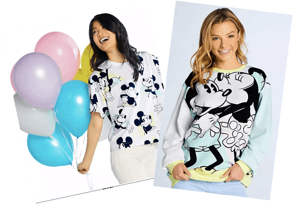 Disney fans radiate joy in matching Mickey Mouse shirts from shopDisney, with one holding pastel balloons as both smile brightly—capturing the magic and playful spirit of the parks.