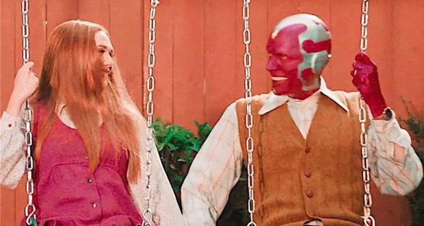 Guests dressed in retro outfits enjoy the swings at a themed park attraction, holding hands and laughing together in a yard scene reminiscent of WandaVision’s classic sitcom era—a picture-perfect moment to capture the magic of immersive entertainment for fans on social media.