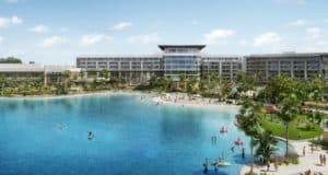 Evermore Orlando Resort offers a vibrant summer getaway just minutes from Walt Disney World, featuring modern accommodations surrounded by palm trees, guests swimming and kayaking in a crystal-clear blue lagoon under sunny skies—an ideal retreat for theme park fans seeking relaxation and adventure during Summer 2023.