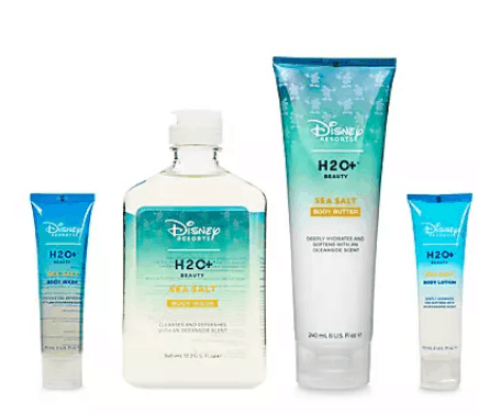 Four bottles of Disney Resort H2O+ Beauty Sea Salt bath and body products, showcased in their signature blue and white packaging, are lined up just like the luxurious toiletries guests enjoy during their stay at Disney Resorts. Experience the magic of Walt Disney World or Disneyland at home with these iconic H2O+ amenities, now available on Amazon.