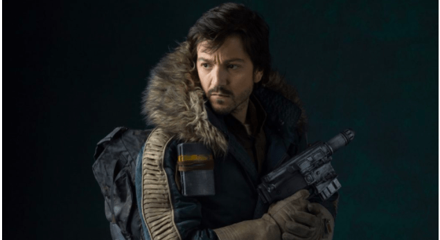 A Star Wars: Andor character in a fur-lined parka poses with a blaster against a dramatic, moody backdrop, capturing the immersive and gritty atmosphere of the galaxy far, far away experienced at Star Wars-themed attractions.