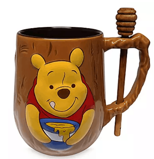 Exclusive Walt Disney World brown Winnie the Pooh mug, showcasing Pooh Bear delighting in his beloved honey, complete with an attached honey dipper on the handle for a magical touch from the Hundred Acre Wood.