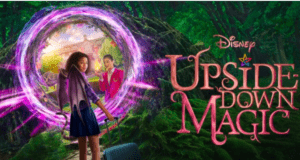 A young guest with a suitcase stands beside a glowing portal set in an enchanted forest, as the sign "Disney Upside-Down Magic" transports viewers into the whimsical world of Disney+—capturing the excitement and imagination you’d find at a Disney Parks magical adventure zone.