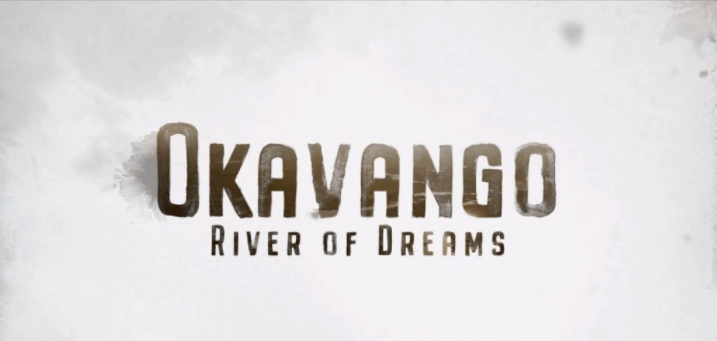 The words "Okavango River of Dreams," an Original Series on Disney+, appear in bold, dramatic letters across a bright, cloud-filled backdrop, evoking the wonder and cinematic feel of a Disney Parks attraction poster.