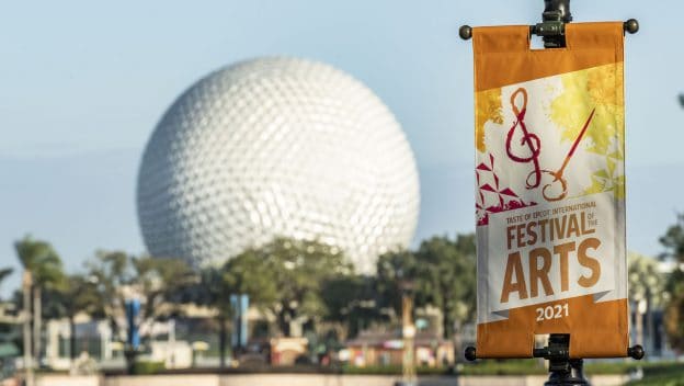 Festival of the Arts 2021 banner set against Epcot's iconic Spaceship Earth, showcasing the colorful excitement and creative energy at Disney EPCOT International Festival of the Arts.
