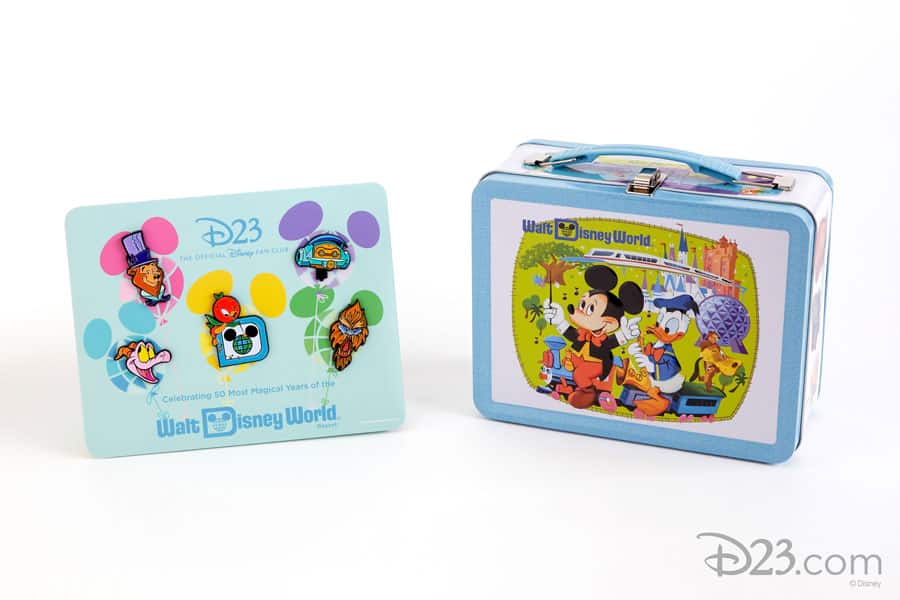 Exclusive Disney Collector Set pins are showcased on a board beside a Walt Disney World lunchbox decorated with Mickey Mouse and friends. A magical addition for Disney fans and D23 members looking to celebrate the magic of the parks!.