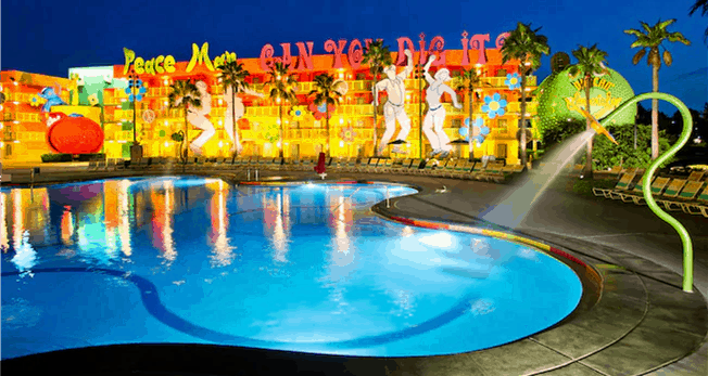 Disney’s Pop Century Resort shines with bold pop art décor, larger-than-life dancing statues, and the legendary Hippy Dippy Pool glowing at night amid towering palm trees—an unmissable attraction freshly enhanced by recent refurbishments for an even more vibrant stay in the heart of Walt Disney World.