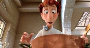Remy, the lovable rat from Ratatouille, sits atop Chef Linguini’s head as he peers into a giant pot in a brightly lit kitchen set, capturing the magic and fun of Disney’s Ratatouille TikTok Musical that raised over $1 million for the Actors Fund.