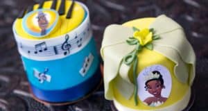 Two vibrant mini cakes at Disney Springs’ Amorette’s Patisserie, celebrating “The Princess and the Frog” with charming character details and playful music note decorations—must-try magical treats for Disney Parks fans.