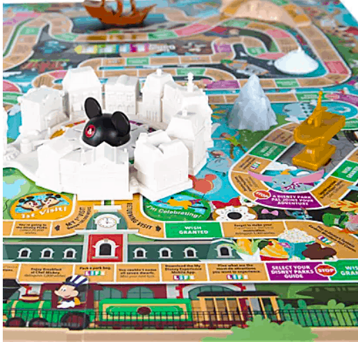 Vibrant board game inspired by The Game of Life: Theme Park Edition, featuring 3D replicas of Disney park icons like Cinderella Castle, a golden Jungle Cruise boat, Mickey Mouse figure, and Space Mountain.