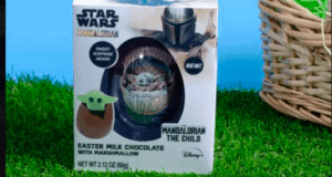 Mandalorian Easter milk chocolate box from the Star Wars universe, showcasing a charming Chocolate Egg and Baby Yoda (Grogu) relaxing on green grass with a vibrant blue backdrop, perfect for fans at Galaxy’s Edge or any themed entertainment venue.