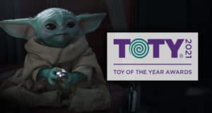 Grogu (Baby Yoda) delights fans by showcasing a Star Wars toy beside the 2021 Toy of the Year Awards (TOTY) logo, celebrating its recognition as one of the galaxy’s top collectibles.