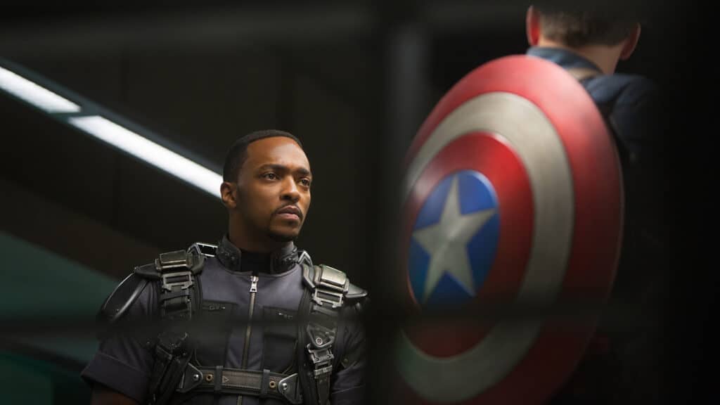 A Marvel hero in tactical gear stands beside a guest holding Captain America’s iconic shield inside an immersive, Legends-inspired attraction. The famous shield nods to the Falcon’s storyline, inviting visitors to relive favorite Marvel moments and heroic adventures.
