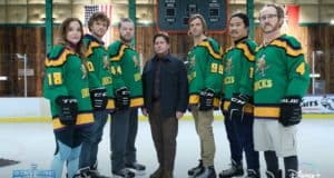 The Mighty Ducks, dressed in their iconic green hockey jerseys, gather for a group photo on the ice rink, smiling at the camera just like they do in the hit Disney+ series.