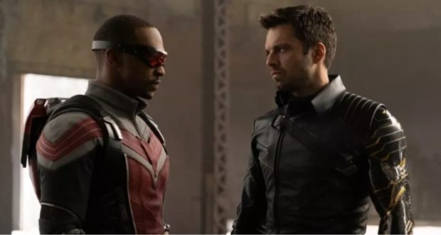 The Falcon and the Winter Soldier stand face-to-face in full superhero gear, sharing a serious moment in a dramatically lit, industrial-themed setting—capturing the high-stakes excitement teased in Disney+ series trailers that Marvel fans can’t wait to experience.